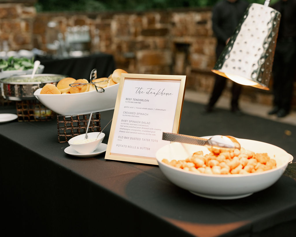 Station style food for a wedding with black table cloth 
